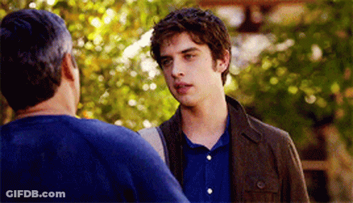 A Man In A Blue Shirt Is Talking To Another Man GIF