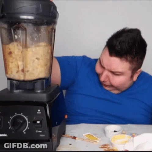 A Man In A Blue Shirt Is Using A Vitamix Blender To Make Food GIF