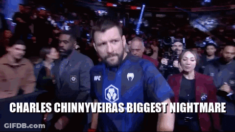A Man In A Blue Shirt Is Walking Out Of A Boxing Ring . GIF