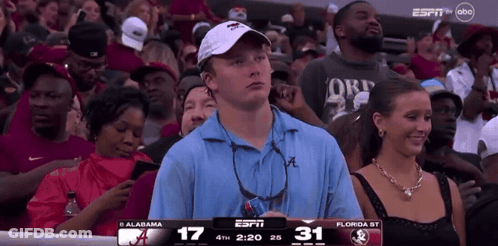 A Man In A Blue Shirt Is Watching A Game On Espn GIF
