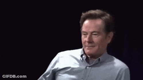 A Man In A Blue Shirt Is Waving At The Camera GIF