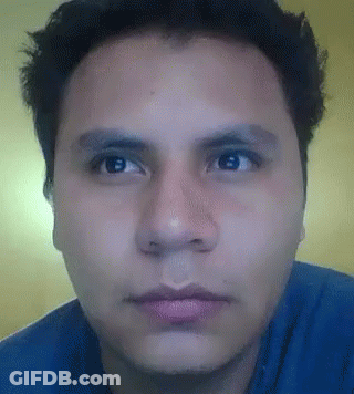 Man In Blue Shirt Looking At Camera GIF