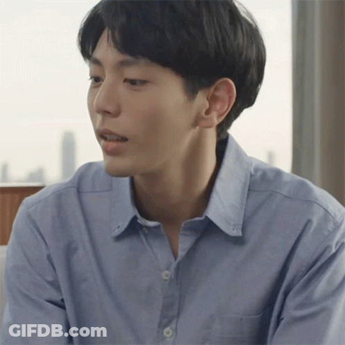 A Man In A Blue Shirt Looks To His Left GIF