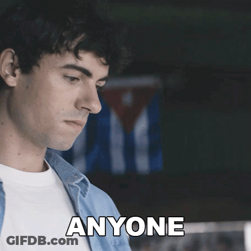 A Man In A Blue Shirt Says " Anyone " In Front Of A Cuban Flag GIF