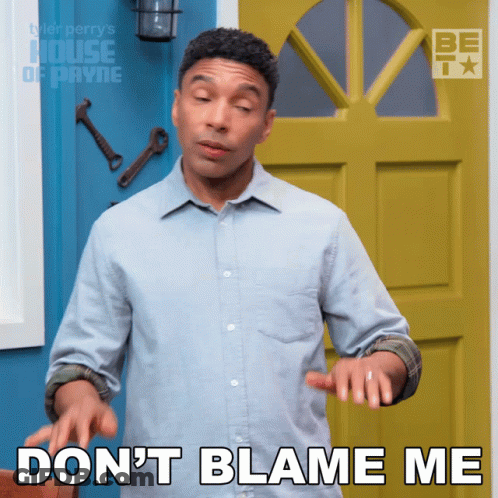 A Man In A Blue Shirt Says " Do N't Blame Me " In Front Of A Yellow Door GIF