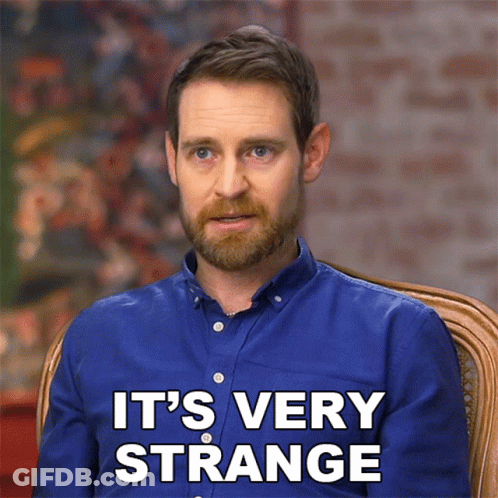 A Man In A Blue Shirt Says " It 'S Very Strange " While Sitting In A Chair GIF