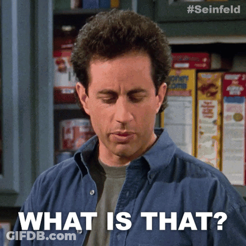 A Man In A Blue Shirt Says What Is That In Front Of A Shelf Of Corn Flakes GIF