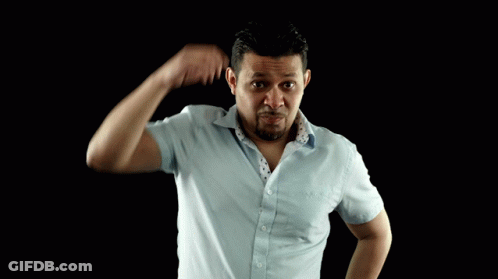 A Man In A Blue Shirt Scratches His Head With His Hand GIF