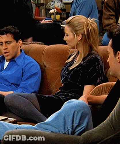 A Man In A Blue Shirt Sits Next To A Woman In A Black Dress GIF
