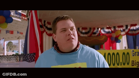 A Man In A Blue Shirt Stands In Front Of A Sign That Says ' Grand Prize ' GIF