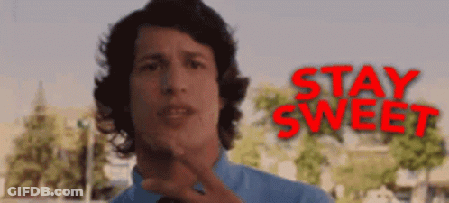 A Man In A Blue Shirt Stands In Front Of A Sign That Says Stay Sweet GIF