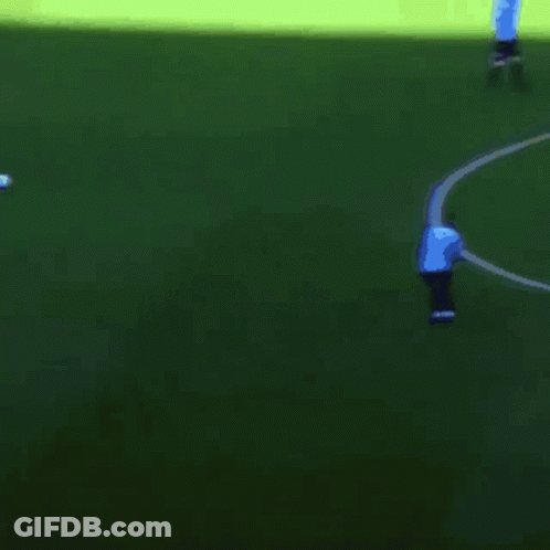 A Man In A Blue Shirt Stands On A Green Field GIF