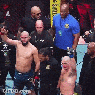 A Man In A Blue Shirt That Says UFC Stands In Front Of A Group Of Men GIF