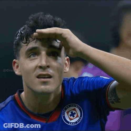 A Man In A Blue Shirt With A Cross On It GIF