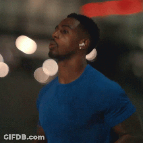 A Man In A Blue Shirt With Ear Buds On GIF