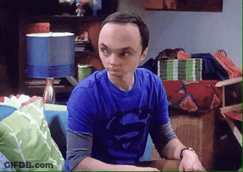 A Man In A Blue Shirt With Superman On It Is Sitting On A Couch GIF