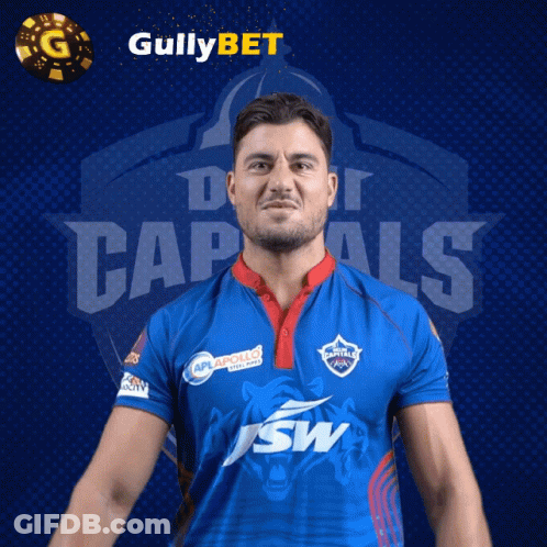 A Man In A Blue Shirt With The Word Capitals On The Front GIF