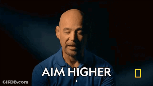 A Man In A Blue Shirt With The Words Aim Higher Above Him GIF