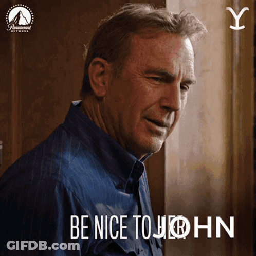 A Man In A Blue Shirt With The Words Be Nice To John GIF