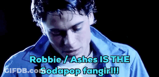 A Man In A Blue Shirt With The Words Robbie / Ashes Is The Sodapop Fangirl Written Below Him . GIF
