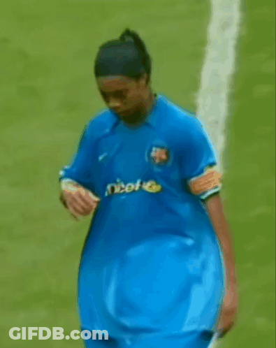 A Man In A Blue Shirt With Unicef On It Is Walking On A Field . GIF
