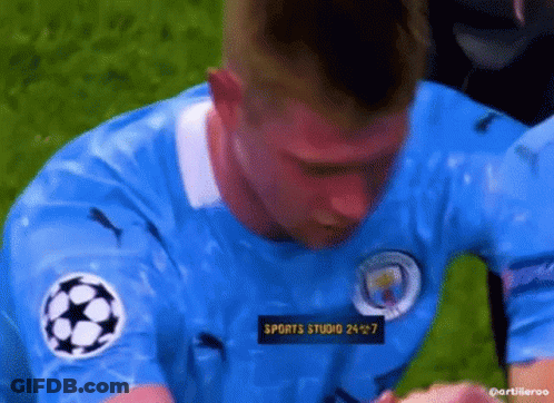 A Man In A Blue Soccer Jersey Is Kneeling On The Field . GIF