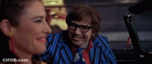 A Man In A Blue Striped Suit And Tie Is Smiling While Sitting In A Car Next To A Woman . GIF