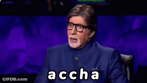 A Man In A Blue Suit And Glasses Is Sitting In Front Of A Purple Background And Making A Funny Face . GIF