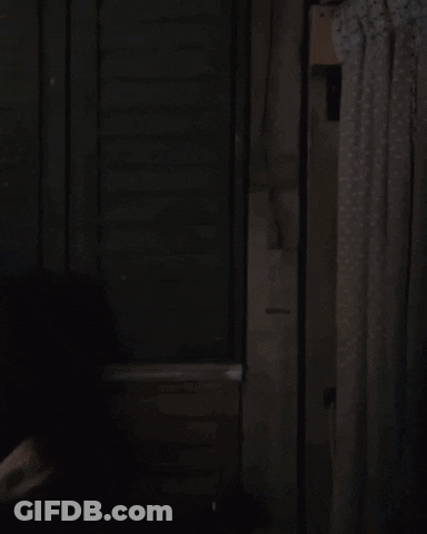A Man In A Blue Suit And Glasses Is Walking Through A Doorway GIF