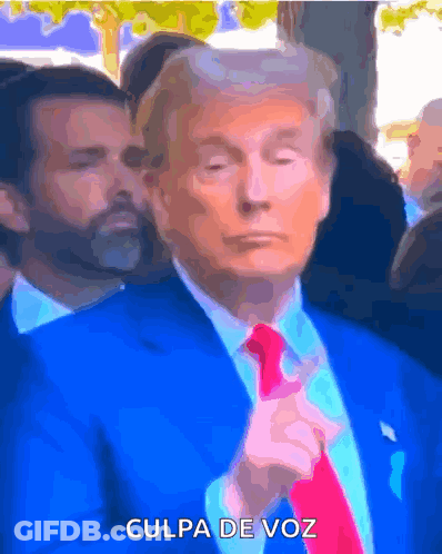 A Man In A Blue Suit And Red Tie Says " Culpa De Voz " On The Bottom GIF