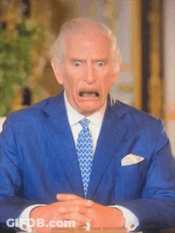 A Man In A Blue Suit And Tie Is Making A Surprised Face GIF