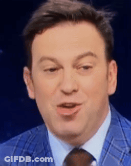 A Man In A Blue Suit And Tie Is Smiling GIF