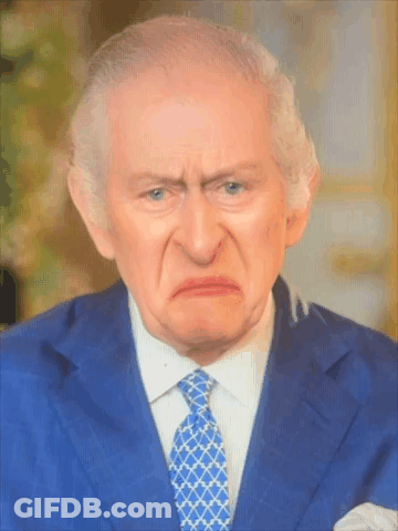 A Man In A Blue Suit And Tie Making A Funny Face GIF