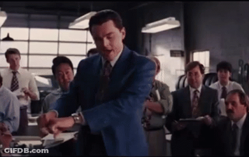 A Man In A Blue Suit And Tie Stands In Front Of A Group Of Men In Suits And Ties . GIF