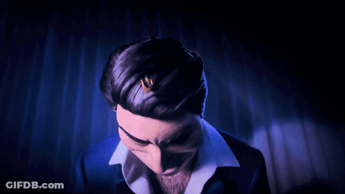 A Man In A Blue Suit And White Shirt Is Making A Funny Face GIF