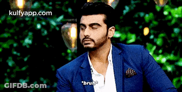 A Man In A Blue Suit And White Shirt Is Talking To Someone . GIF