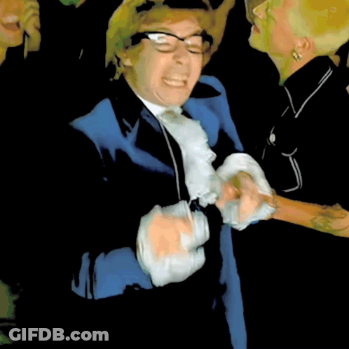 A Man In A Blue Suit And White Tie Is Making A Face GIF