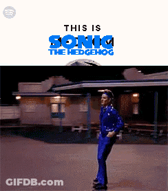 A Man In A Blue Suit Is Standing In Front Of A Building With The Words This Is Sonic The Hedgehog Above Him GIF