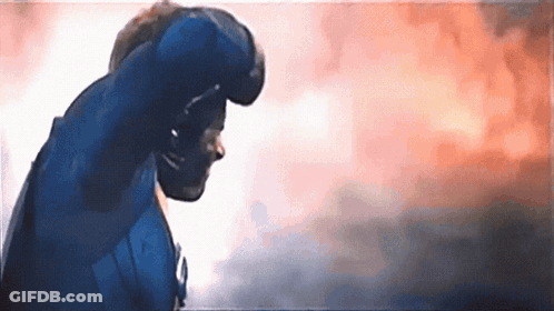 A Man In A Blue Suit Is Standing In Front Of A Cloudy Sky . GIF