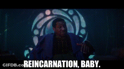 A Man In A Blue Suit Is Standing In Front Of A Stained Glass Window . GIF