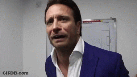 A Man In A Blue Suit Is Standing In Front Of A White Board With A Soccer Field Drawn On It GIF
