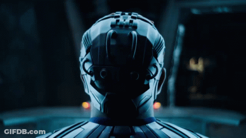 A Man In A Blue Suit Is Standing Next To A Woman In White GIF