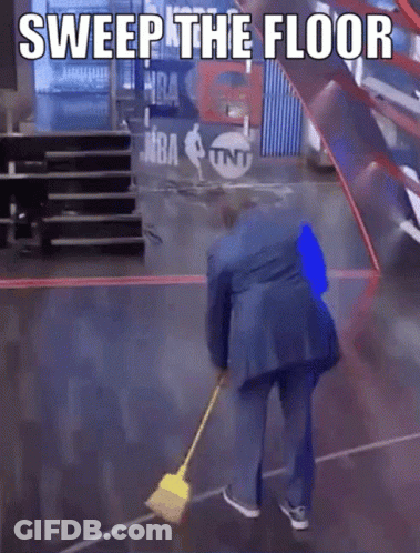 A Man In A Blue Suit Is Sweeping The Floor With A Yellow Broom GIF
