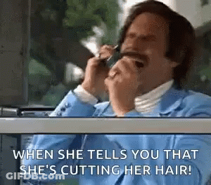 A Man In A Blue Suit Is Talking On A Cell Phone While Looking Out The Window . GIF