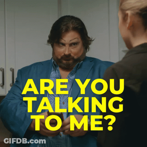 A Man In A Blue Suit Is Talking To A Woman With The Words " Are You Talking To Me " Above Him GIF