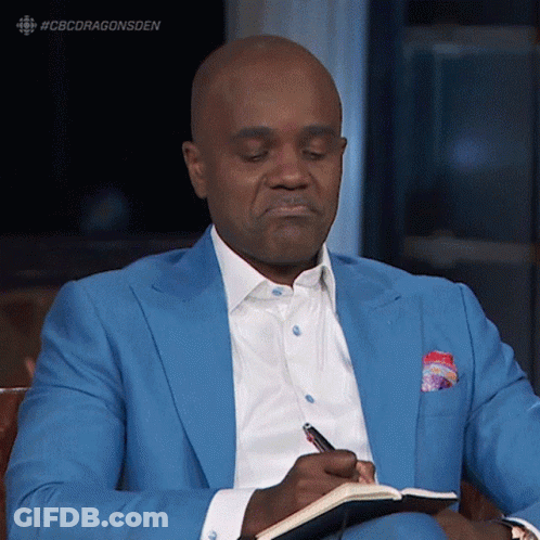 A Man In A Blue Suit Is Writing In A Book GIF