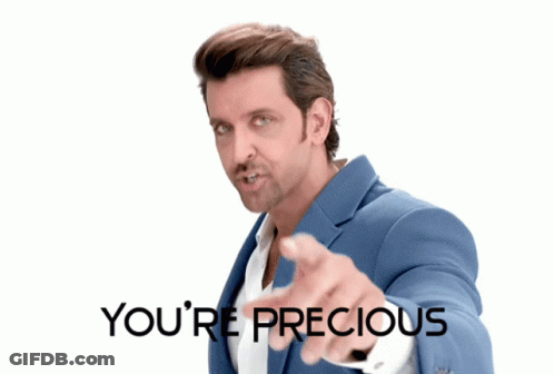 A Man In A Blue Suit Pointing At The Camera With The Words You 'Re Precious Behind Him GIF