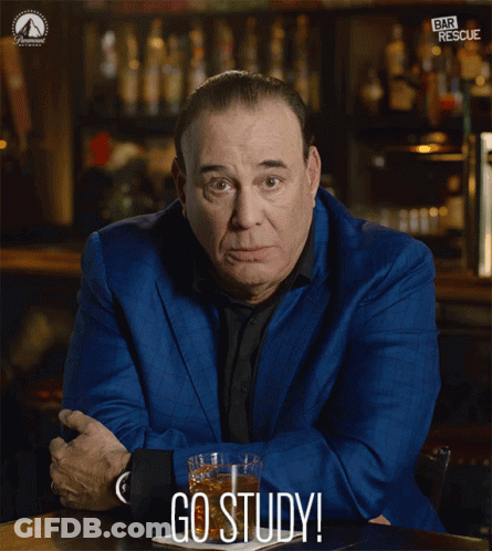A Man In A Blue Suit Sits At A Table With A Glass Of Whiskey And The Words Go Study Below Him GIF