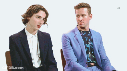 A Man In A Blue Suit Sits Next To Another Man GIF