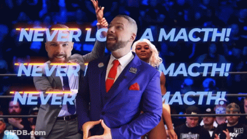 A Man In A Blue Suit Stands In A Wrestling Ring With The Words Never Lose A Macth GIF
